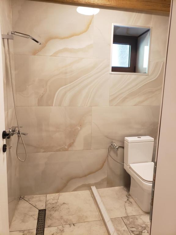 een badkamer met een douche en een toilet bij Guest House Vuthaj in Vusanje