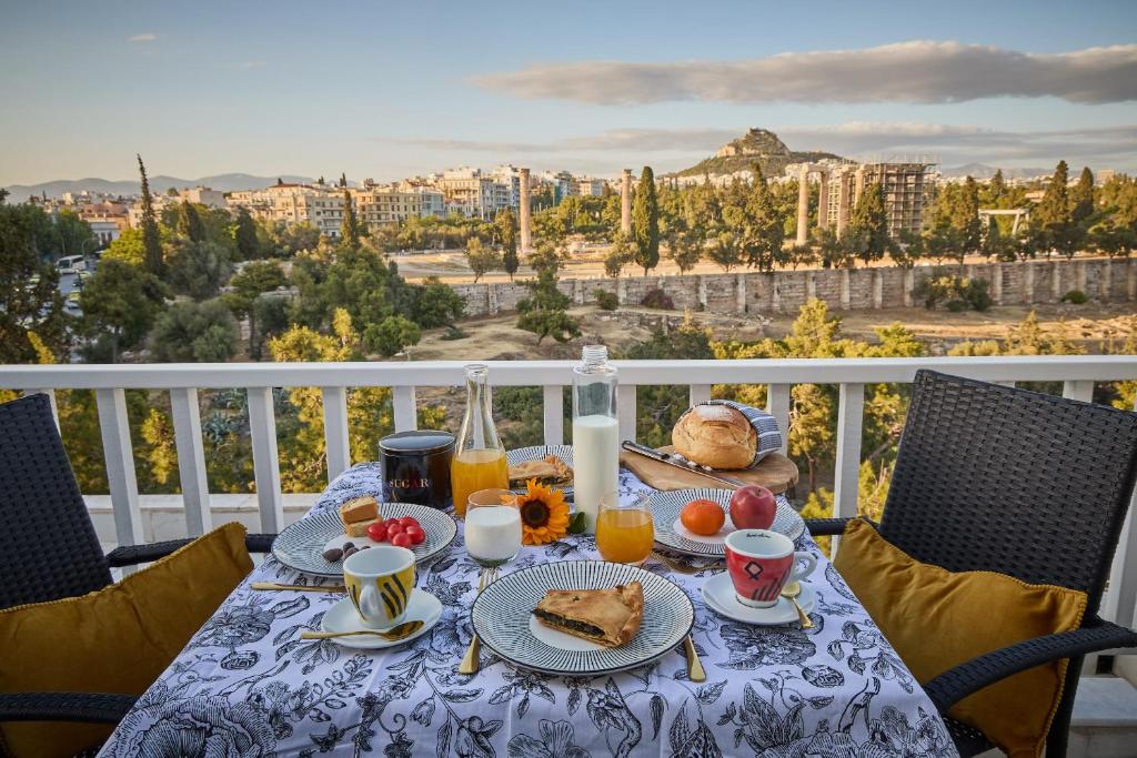 Acropolis Compass Residence في أثينا: طاولة مع طعام الإفطار وعصير البرتقال على الشرفة