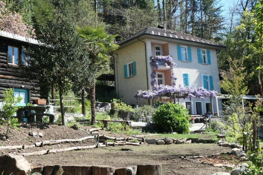 dom z fioletowymi kwiatami z przodu w obiekcie La Pineta w mieście Locarno