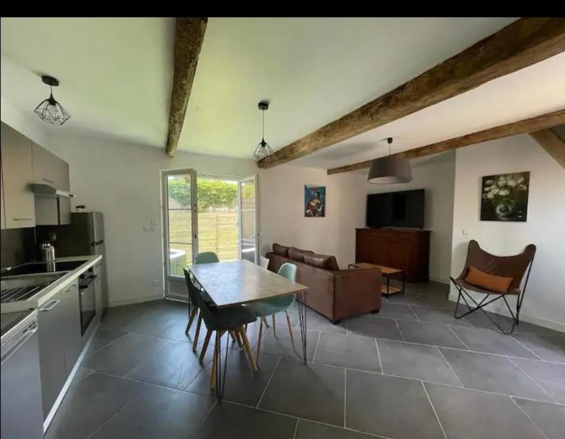 une cuisine et un salon avec une table et un canapé dans l'établissement Jolie maison avec jacuzzi 10 pers, parc Astérix, à Cinqueux