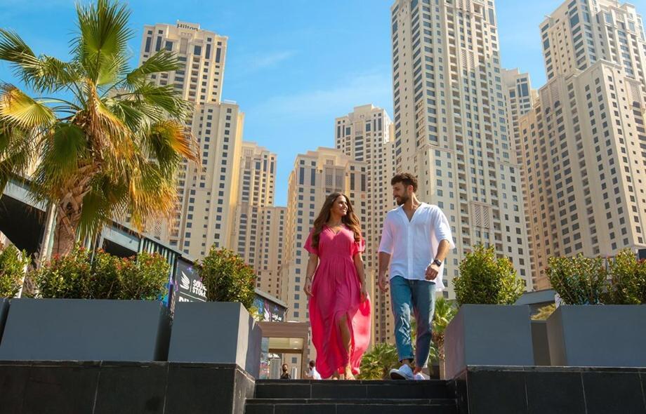 a man and a woman walking down stairs in a city at The W Jumeirah Beach in Dubai