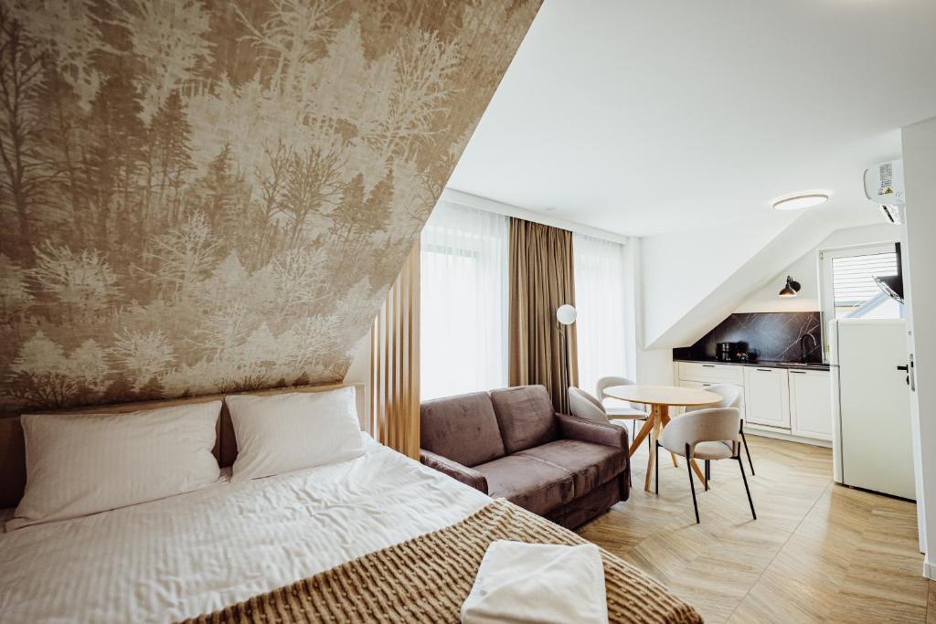 a bedroom with a bed and a couch and a table at Luksusowe apartamenty przyjazne dla rodzin - zwierzęta akceptowane - budynek A in Podgórzyn