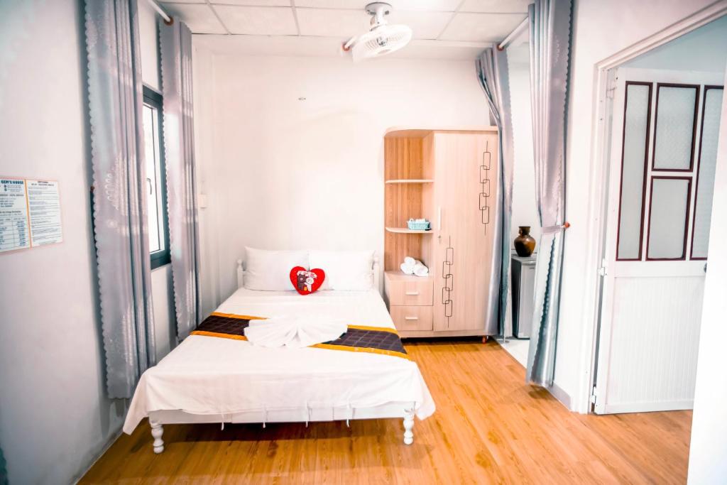 a bedroom with a bed with a red pillow on it at Gem’s House in Mui Ne