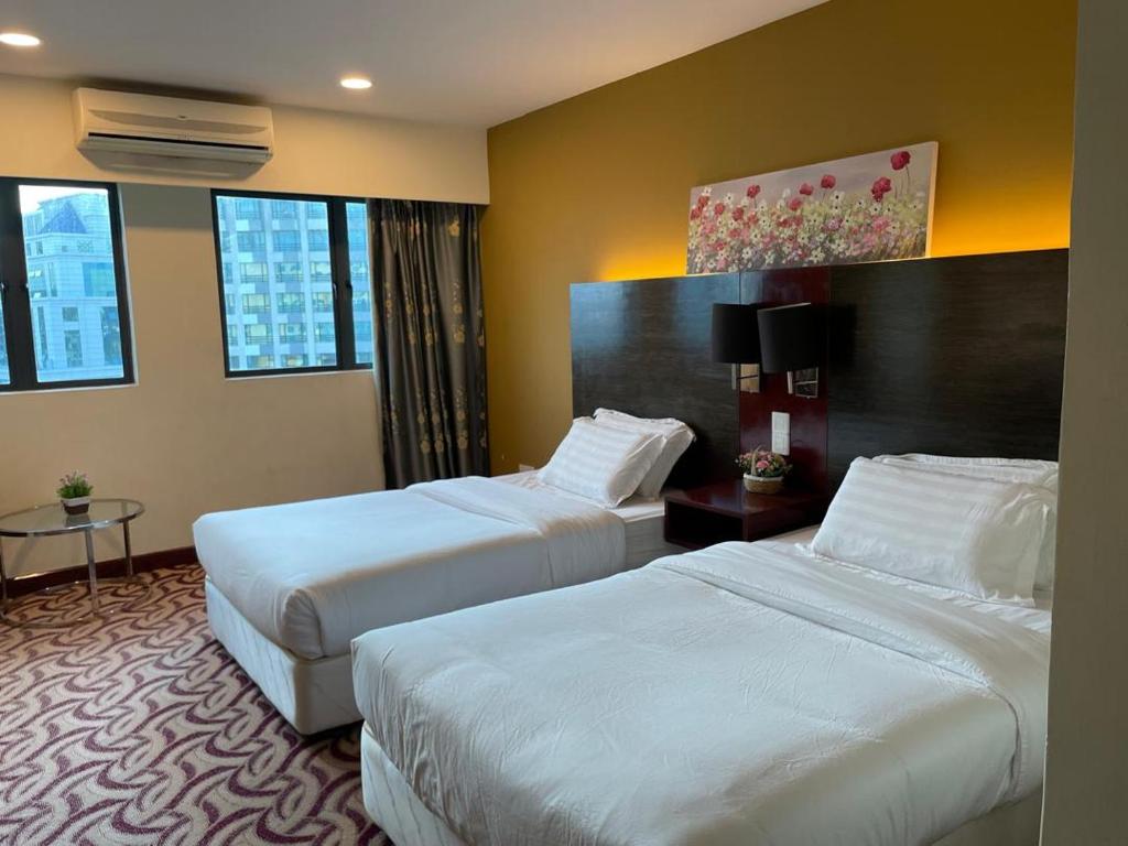 una habitación de hotel con 2 camas en una habitación en KK Homestay City Deluxe room - Ming Garden Hotel & Residence en Kota Kinabalu