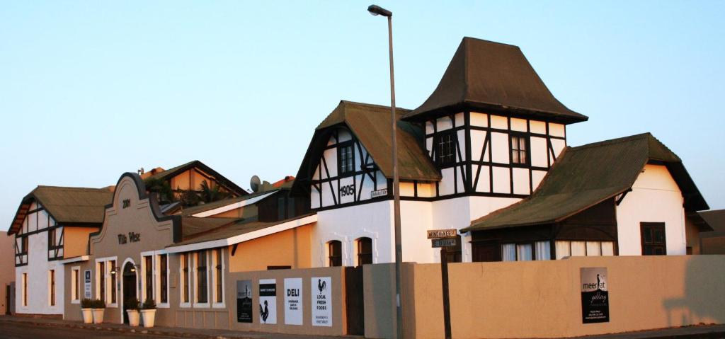 a large white building with a brown roof at The Residence at Villa Wiese in Swakopmund
