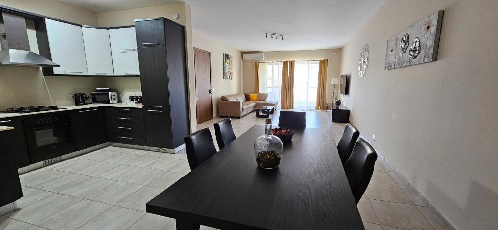 a kitchen and dining room with a table and chairs at Large Apartment in Marsascala. sleeps 6 in Marsaskala