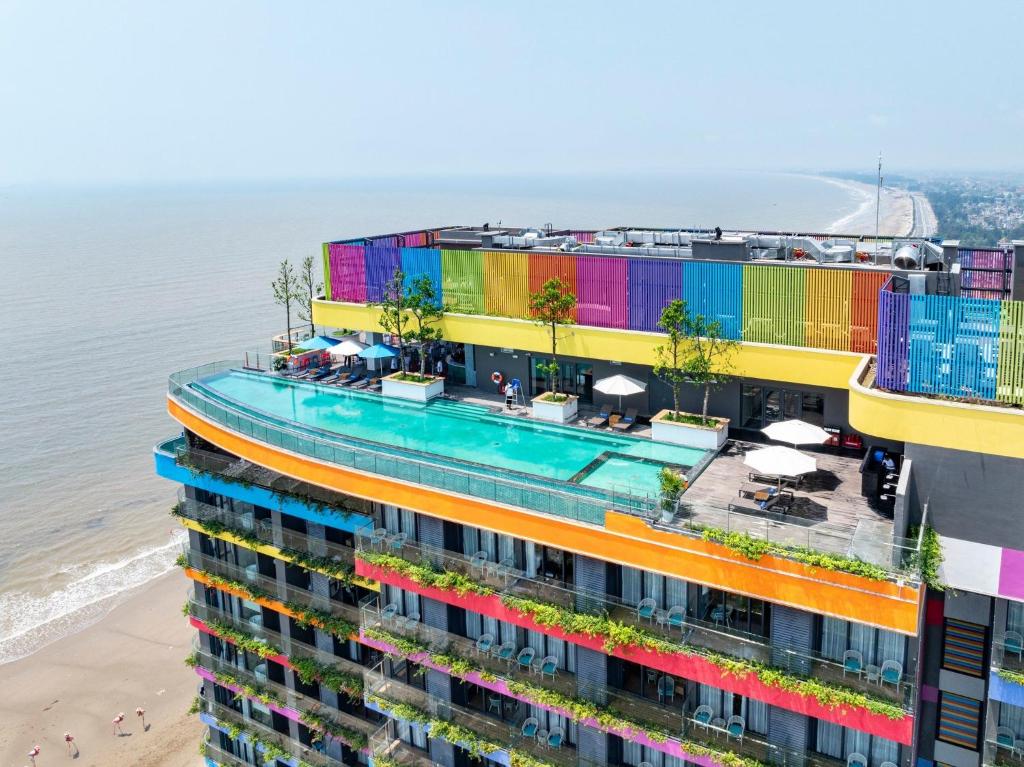 an apartment building with colorful balconies next to the beach at Flamingo Ibiza Hải Tiến in Thanh Hóa