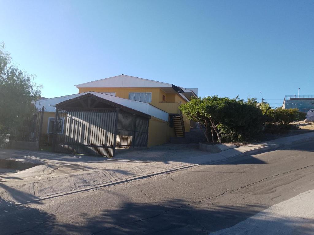 uma casa amarela com uma cerca ao lado de uma rua em departamentos mirador 2 piso em Caldera