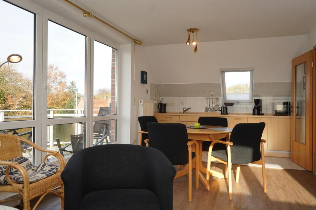 eine Küche und ein Esszimmer mit einem Tisch und Stühlen in der Unterkunft Kurpark Domizil 6 in Cuxhaven