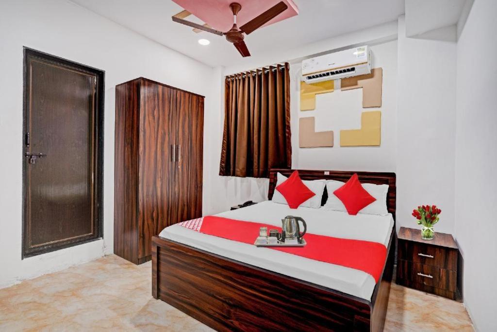 Hotel Terrace Inn في سورات: غرفة نوم بسرير وبطانية حمراء وبيضاء