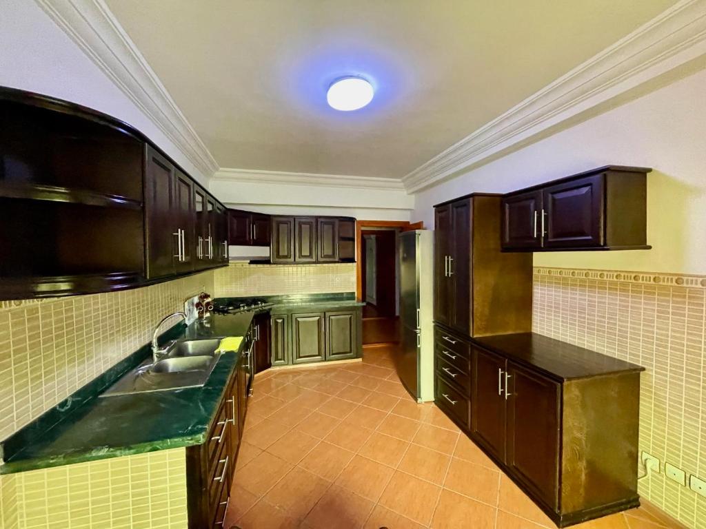 a kitchen with wooden cabinets and a sink at Sary's Hotel in M'diq