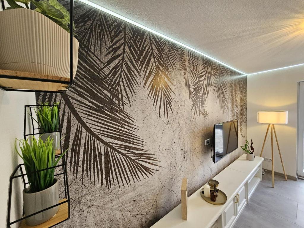 a living room with a wall mural of palm trees at Ferienhaus am Stadtpark, 3 Schlafzimmer, Wozi mit Bett und Schalfsofa,Businesswohnung, Monteurezimmer in Salzgitter