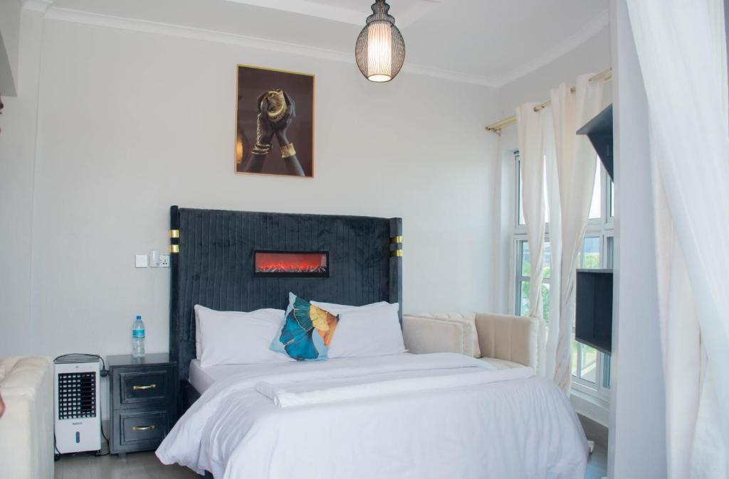 um quarto com uma cama grande e lençóis brancos em Ladari Apartments em Babati
