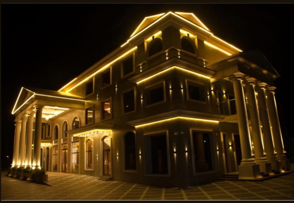 a large building with lights on it at night at raj Regent kurichy in Putuppalli