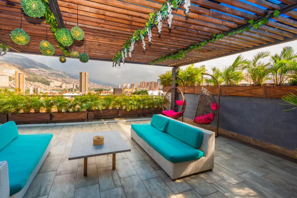 um pátio com um sofá azul e uma mesa em Hotel Perlatto em Bello