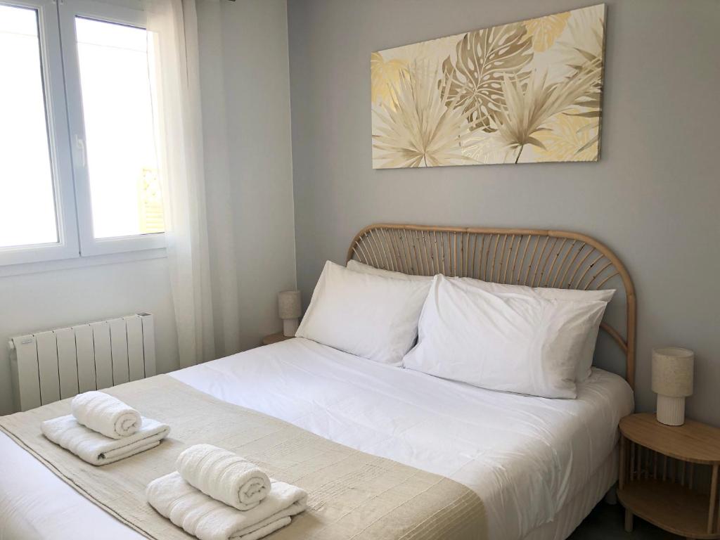 a bedroom with a bed with two towels on it at La Palaine, maison à 150m de la mer in La Plaine-sur-Mer