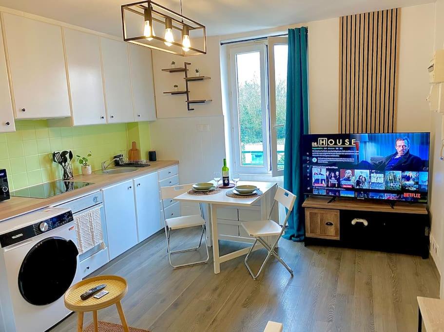Il comprend une cuisine avec une table et une télévision. dans l'établissement Calme Wifi Fibre Netflix Gare à pied, à Corbeil-Essonnes