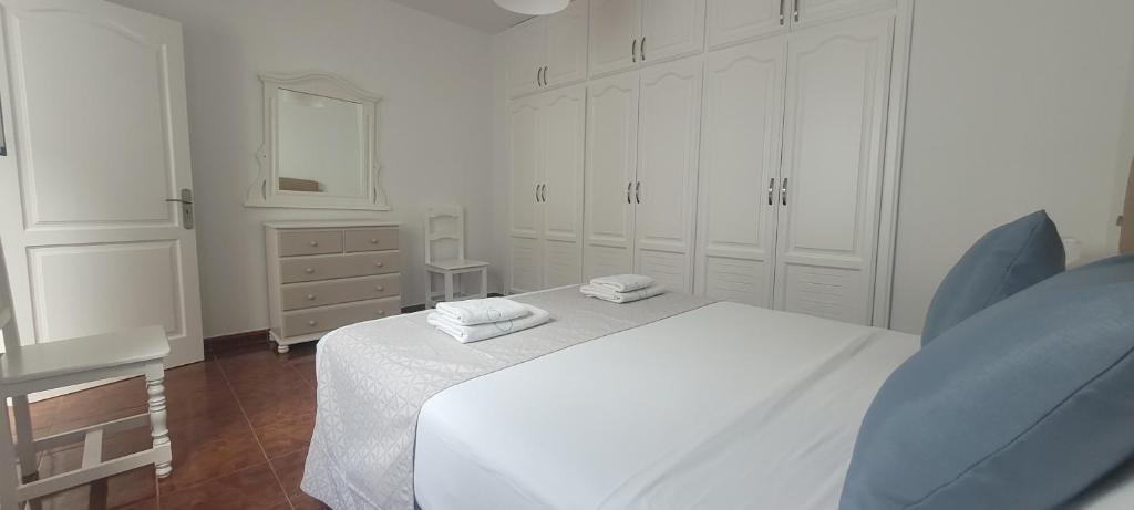 a white bedroom with a bed and a dresser at Sabbia Suites Casa San Miguel in Teguise