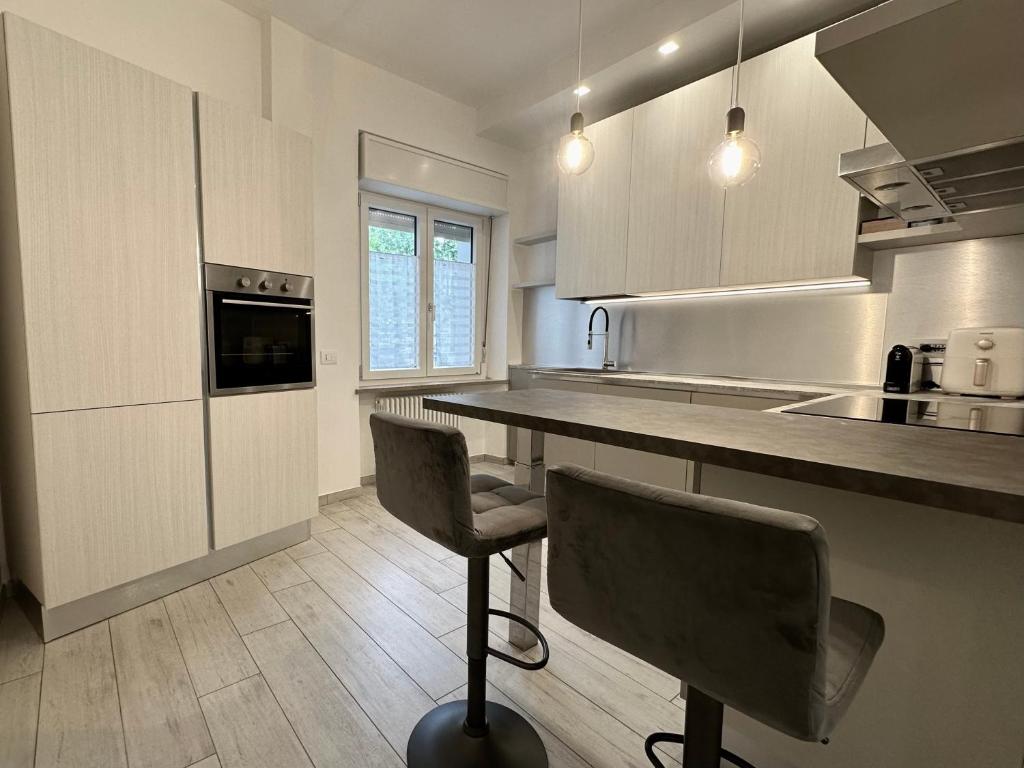 Hotel Four Season Rimini apartments 130mq Esclusivo, a kitchen with a counter and two chairs in it at Four Season Rimini apartments 130mq Esclusivo in Rimini