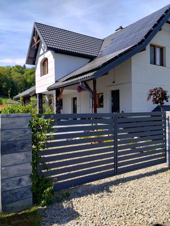 a house with a fence in front of it at Apart Home Bieszczady in Uherce Mineralne