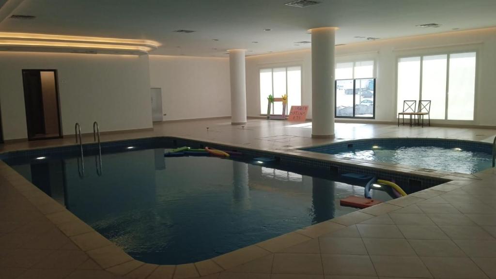 una piscina en una habitación grande con piscina en برج ماجيك سويت Magic Suite Tower, en Kuwait