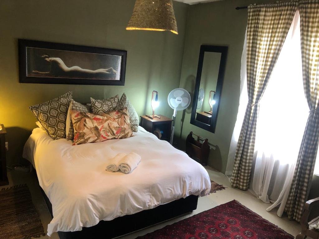 The Riverdeck Accommodation and Backpackers في كنيسنا: غرفة نوم عليها سرير وفوط