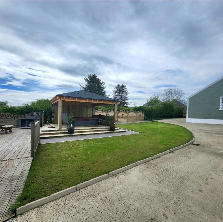 a gazebo with a bench in a yard at Woodside guest house in Castlerock