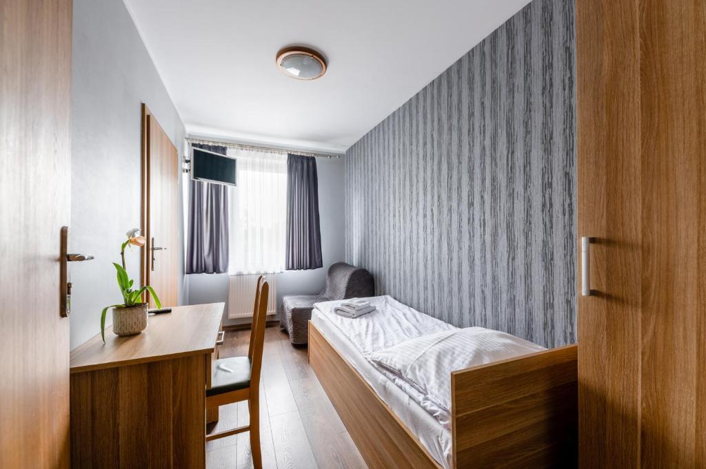 a bedroom with a bed and a desk and a chair at Sleep&Go in Lubliniec