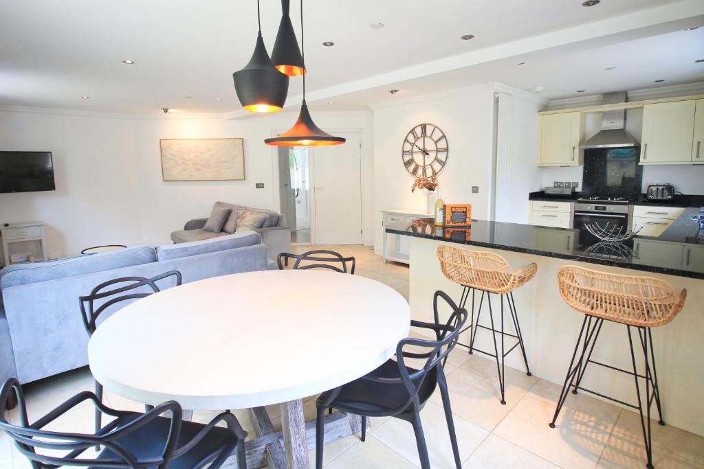 eine Küche und ein Wohnzimmer mit einem weißen Tisch und Stühlen in der Unterkunft CLOSE TO BEACH, dogs welcome, private garden in Saint Merryn