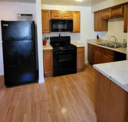 a kitchen with a black refrigerator and wooden floors at U3 - Comfortable 1 BR & 1 BA APT in DT PHX with pkg in Phoenix