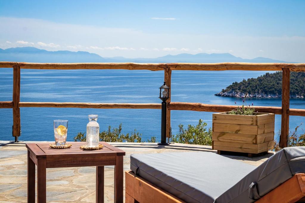 a view of the ocean from a deck with a bed and a table at Camellia Home - Pure Sea View in Skopelos Town