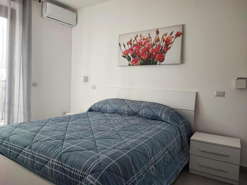 um quarto com uma cama azul e um vaso de flores em Casa vacanze Hoffman em Caltagirone