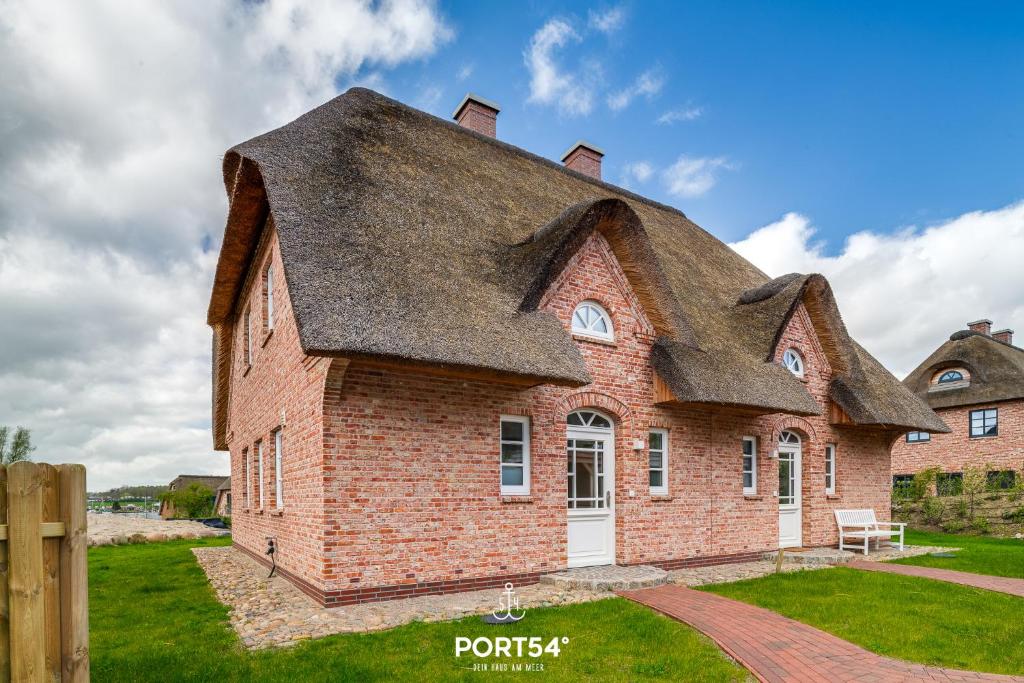 an old brick house with a gambrel roof at Reetdachkate Reethüüs Kappeln in Kappeln