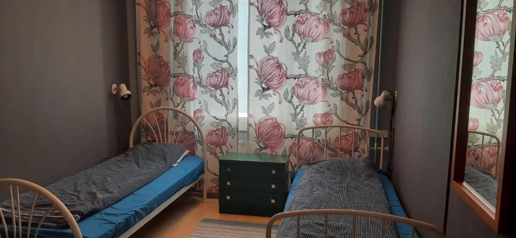 um pequeno quarto com 2 camas e um espelho em Furnished 2 room appartment in Vasa em Vaasa