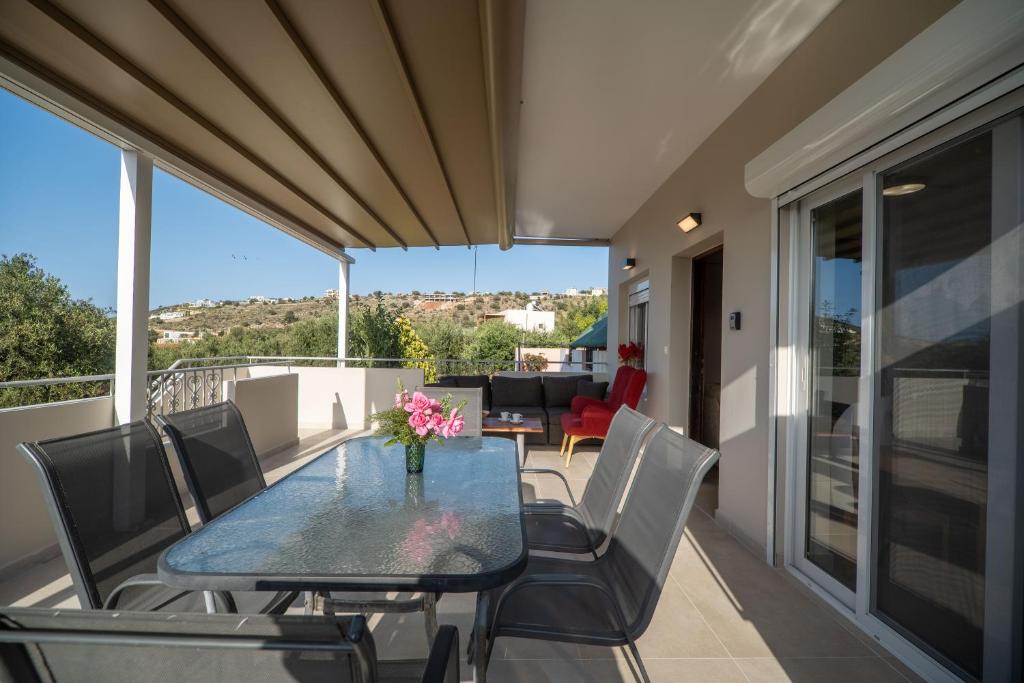 a patio with a table and chairs on a balcony at Tranquil Retreat in Apokoronas - Chania in Kókkinon Khoríon