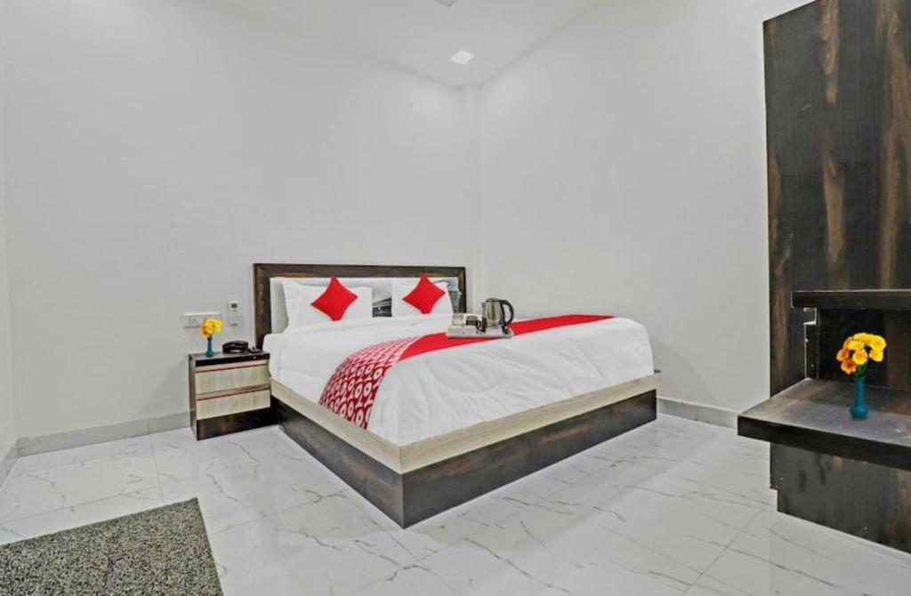 hotel chahat palace في آغْرا: غرفة نوم بسرير كبير ومخدات حمراء