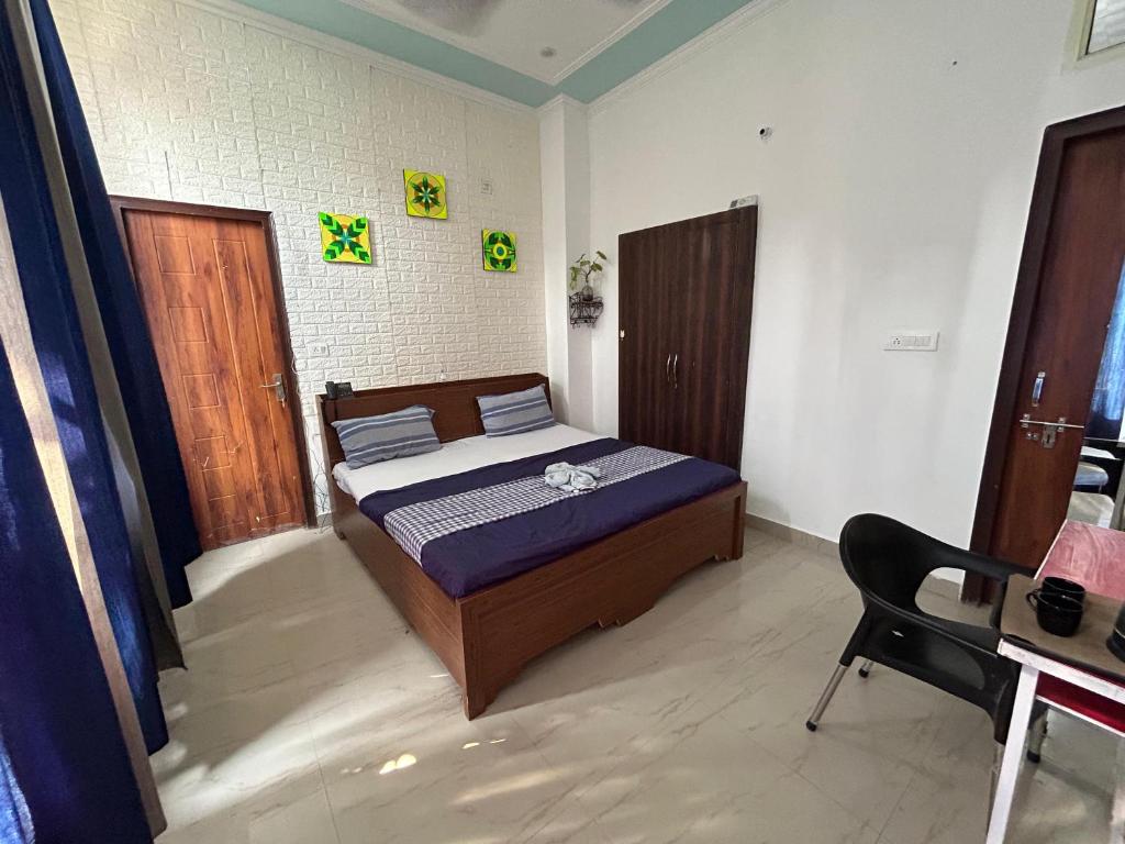 um quarto com uma cama e uma cadeira em Home UbEx em Rishikesh