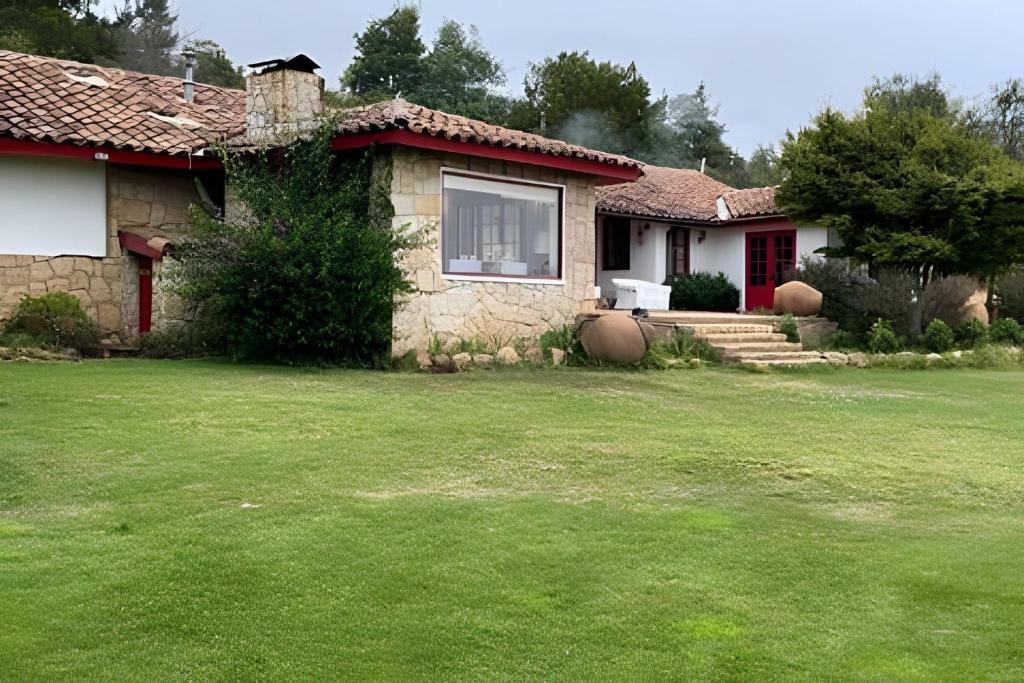 a house with a grass yard in front of it at Casa de Campo con vista al mar in Chanco