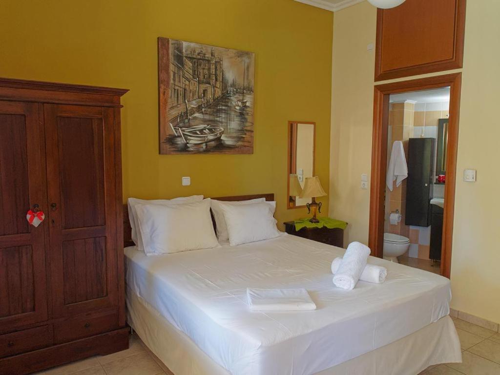 een slaapkamer met een groot wit bed in een kamer bij N&M-Methana in Methana