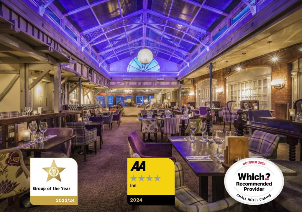 a restaurant with purple ceilings and tables and chairs at The Admiral Rodney Hotel, Horncastle, Lincolnshire in Horncastle