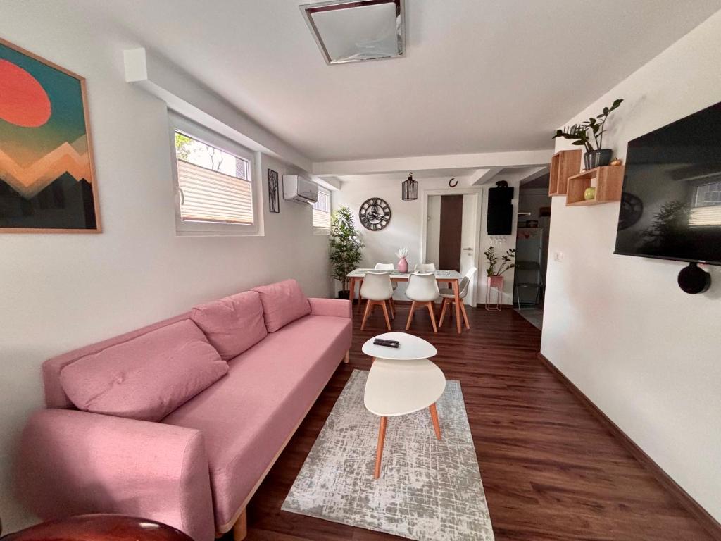 Una sala de estar con un sofá rosa y una mesa. en Sunset Bled, en Bled