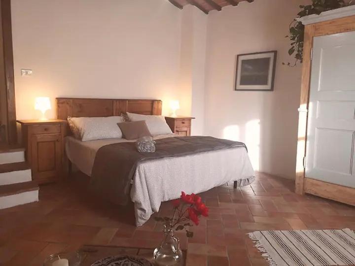 1 dormitorio con 1 cama y un jarrón de flores en Fantastic Apartment in the Heart of Toscana en Castiglion Fiorentino