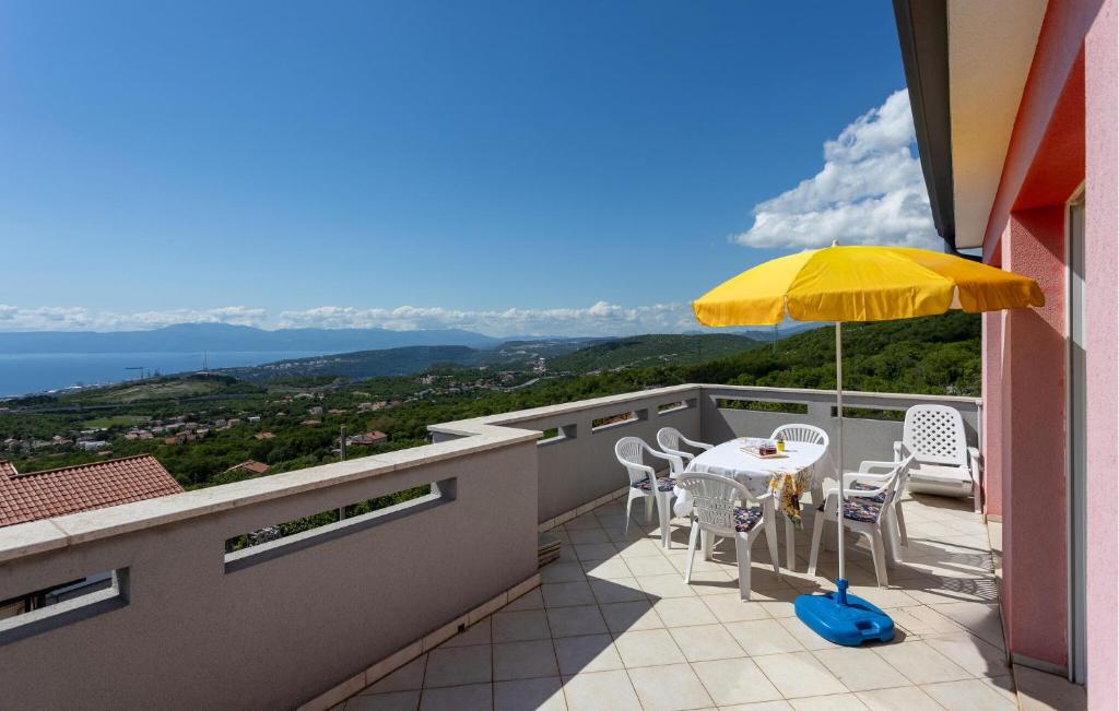 een balkon met een tafel en stoelen en een parasol bij Lovely Apartment In Hreljin With House Sea View in Hreljin