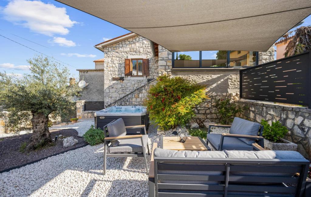 a patio with chairs and a grill and a house at 4 Bedroom Stunning Home In Vlasici - Krsan in Kršan