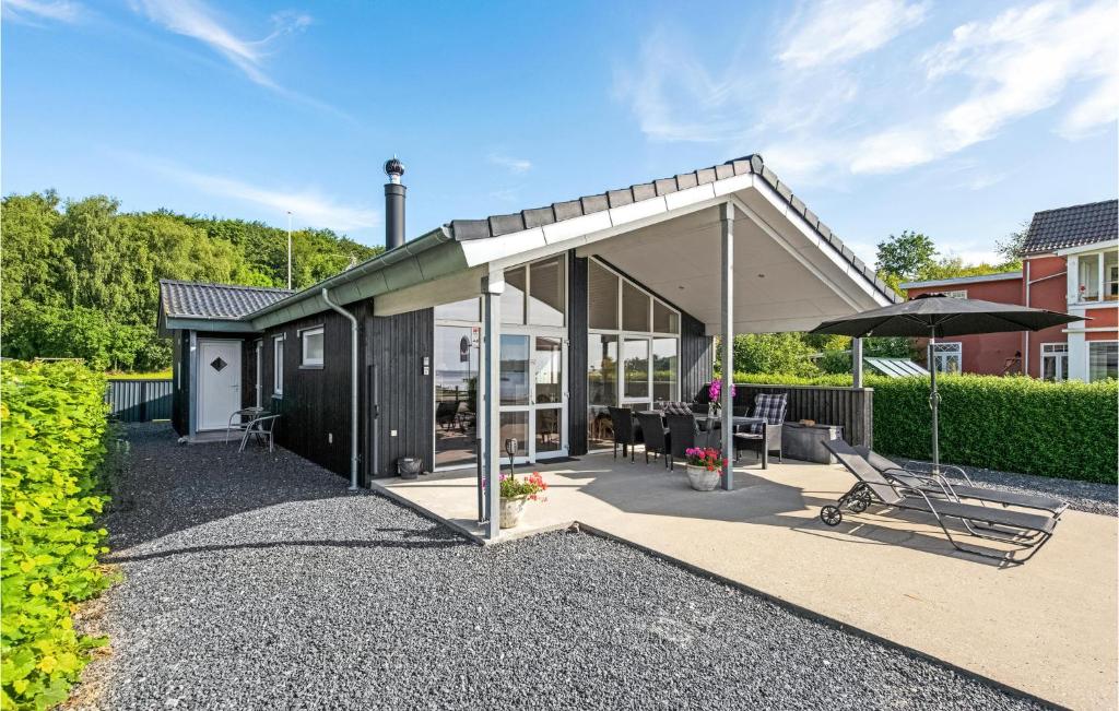 a pavilion with a table and an umbrella at Holiday Home Sønderballevej Rødekro I in Diernæs