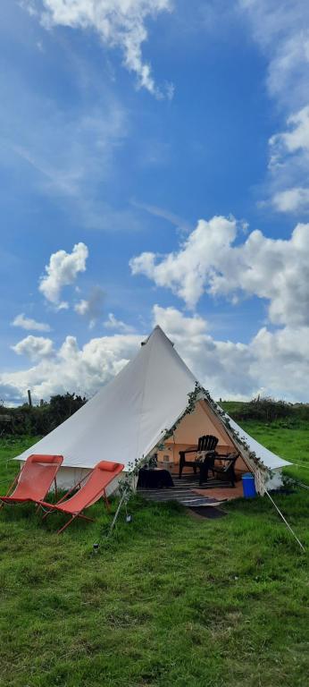 biały namiot ze stołem piknikowym na polu w obiekcie Summit Camping Kit Hill Cornwall Stunning Views Pitch Up or book Bella the Bell Tent w mieście Callington