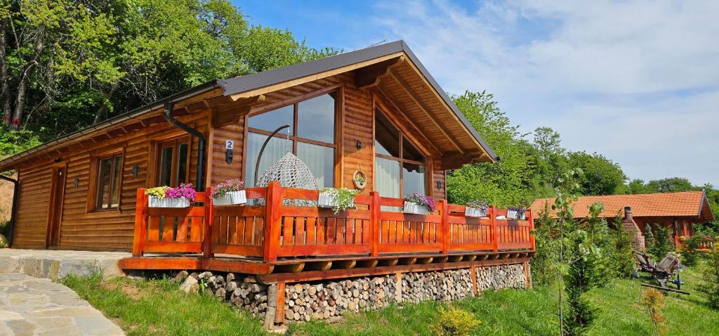 eine Holzhütte mit einem großen Balkon im Hof in der Unterkunft Bioland VILLA's in Novoberdo
