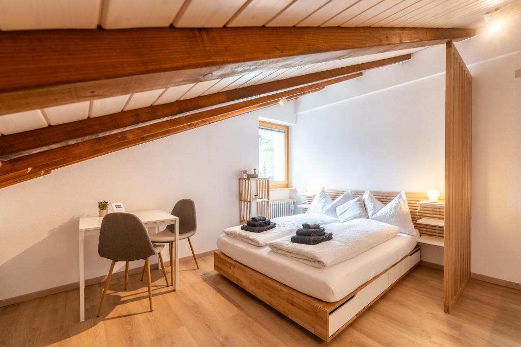 a bedroom with a large bed and a desk at Studio Mundizia in Zermatt