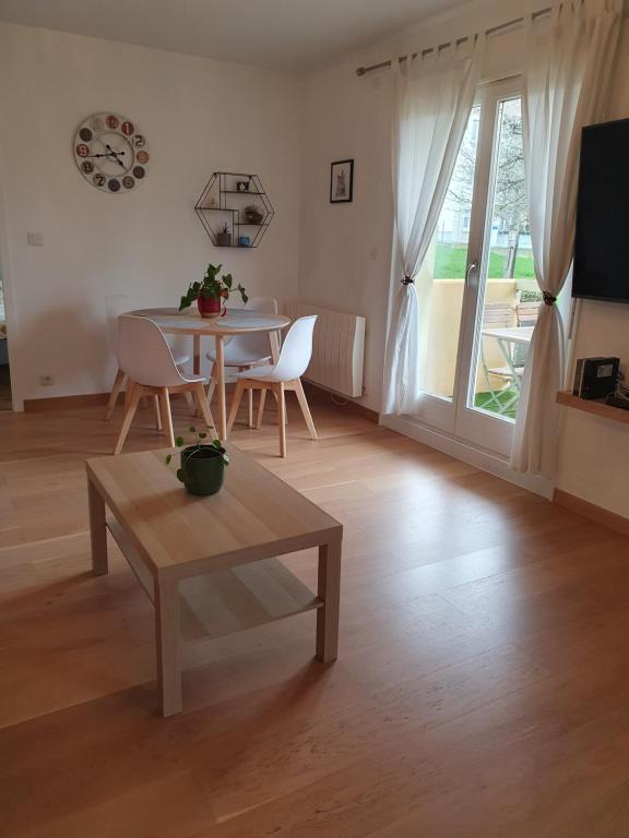 een woonkamer met een tafel en stoelen en een raam bij L'Obernois situé dans 1 résidence privée in Obernai