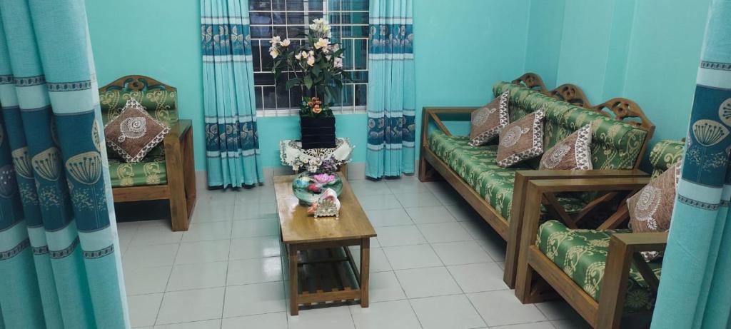 ein Wohnzimmer mit 2 Sofas und einem Tisch in der Unterkunft Zuned Homes Sylhet in Sylhet